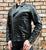 An 80's Metal 'Blade' black leather jacket with a mandarin collar, shoulder and elbow padding, silver metal zippers and a red quilted lining.