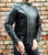 An 80's Metal 'Blade' black leather jacket with a mandarin collar, shoulder and elbow padding, silver metal zippers and a red quilted lining.