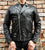 An 80's Metal 'Blade' black leather jacket with a mandarin collar, shoulder and elbow padding, silver metal zippers and a red quilted lining.