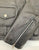 A close up of the zipped cuff on this classic black leather jacket with epaulets on the shoulders, high collar, zipped cuffs, adjustable belt, multiple pockets and a silver satin effect lining.