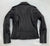 A classic black leather jacket with epaulets on the shoulders, high collar, zipped cuffs, adjustable belt, multiple pockets and a silver satin effect lining.