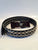 An 80's Glam black leather studded Belt featuring a shiny red and black 'ROCKSTAR' buckle with a silver star.