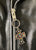 A close up of the zip pull on a metalworks leather jacket featuring Guns N Roses 'Los F'N Angeles' on the back, with epaulets, multiple pockets, adjustable belt and high quality zips.  