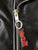 A close up of the zip pull on a metalworks leather jacket featuring Judas Priest 'Defenders Of The Faith' on the back, with epaulets, multiple pockets, adjustable belt and high quality zips.  